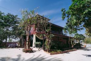 a building with trees in front of it at ชลธี รีสอร์ท in Maha Sarakham