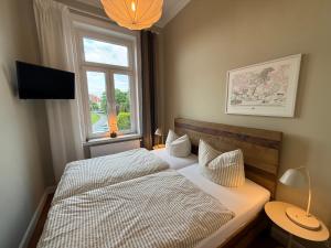 a small bedroom with a bed and a window at Seaside Apartments Austernbank in Cuxhaven