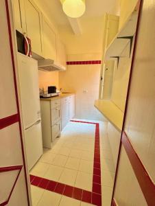 a kitchen with white cabinets and a red and white tile floor at La Dolce Vita in Pisa