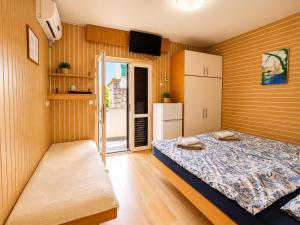 a small bedroom with a bed and a refrigerator at Apartments Pika in Krk