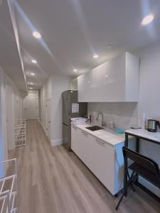 a kitchen with white cabinets and a counter top at Claire House in Vancouver
