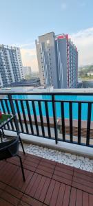 a balcony with a table and a view of a city at Pool View - H&A Signature Klebang in Malacca