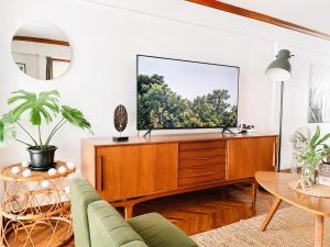 a living room with a television on a wooden dresser at Pannarai's House in Bangkok