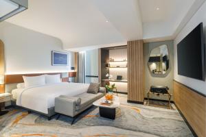 a hotel room with a bed and a tv at Harris Hotel & Convention Serpong in Tangerang