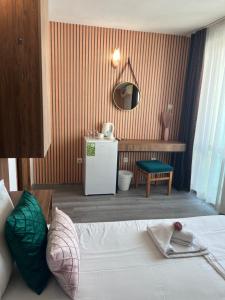 ein Schlafzimmer mit einem Bett und einem kleinen Kühlschrank in der Unterkunft Dreams Family Hotel in Nessebar + 88 Fotos