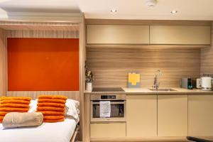 a kitchen with orange towels on a bed and a sink at York Cocoa Suites - city centre apartments in York