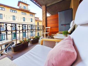 a balcony with a bed and a table and a building at Apt 2 hab Camprodon, chimenea, terraza, céntrico in Camprodon