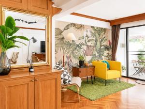 a living room with a yellow chair and a desk at Pannarai's House in Bangkok