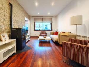 a living room with a couch and a tv at Apt 2 hab Camprodon, chimenea, terraza, céntrico in Camprodon