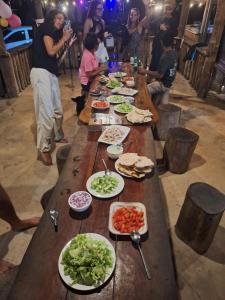 a long wooden table filled with plates of food at Fat Monkey in Koh Rong Island +81 photos