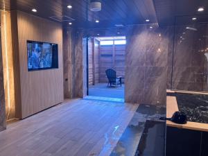 a bathroom with a walk in shower and a chair at Hotel LiVEMAX Tendo in Tendo