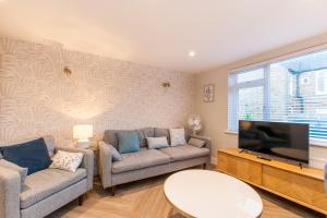 a living room with two couches and a flat screen tv at Marsh House - Modern Apartment With Hot Tub in Whitstable