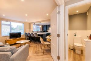 a living room with a couch and a table at Marsh House - Modern Apartment With Hot Tub in Whitstable