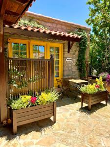 a house with two benches with flowers in front of it at Ilios Guest House in Gokceada Town