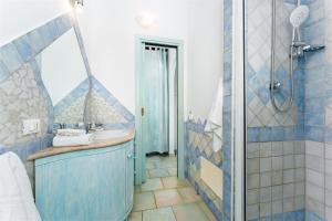 a blue and white bathroom with a sink and a shower at Orosei Domo in Orosei +19 photos