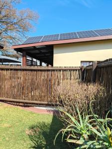 a house with solar panels on a fence at The Museum Cottage in Sabie +6 photos