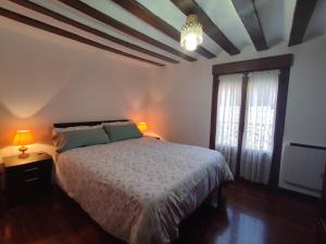 a bedroom with a bed and two lamps and a window at Casona de Barrabás in San Vicente de la Sonsierra