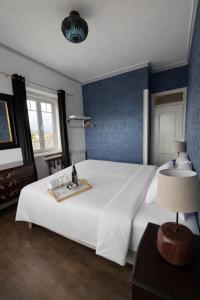 a bedroom with a large white bed with a tray on it at Palacete da Vermelha in Vermelho