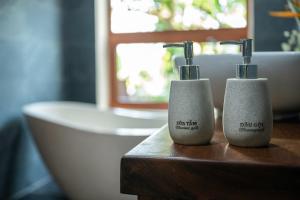 two soap dispensers sitting on a table in a bathroom at Mai Homestay in Ninh Binh
