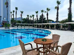a swimming pool with chairs and a table next to a table at Çamyuva Luna Hotel in Kemer