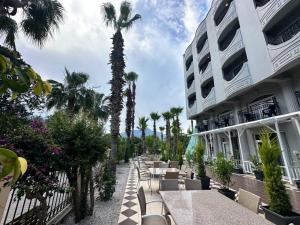 a row of tables and chairs next to a building at Çamyuva Luna Hotel in Kemer