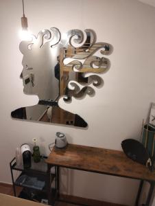 a mirror on a wall next to a wooden table at Outside the Townhall in Piombino
