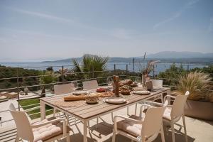 a table and chairs on a balcony with the ocean at Villa Niolos II in Stérnai