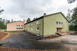 a building with a parking lot in front of it at Spot Apartments Hyrylä in Hyrylä