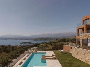a house with a swimming pool with a view of the water at Villa Niolos II in Stérnai