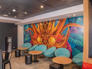 a mural in a restaurant with tables and chairs at ibis Iquique in Iquique