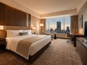 a hotel room with a large bed and a large window at Hotel Krone Plaza Near IGI Airport Delhi in Champawat