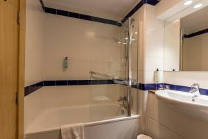 a bathroom with a shower and a tub and a sink at Travelodge Madrid Arturo Soria in Madrid +35 photos