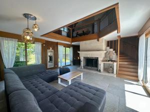 a living room with a couch and a fireplace at Gîte des Pruniers in Saint-Germain-le-Rocheux