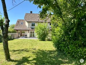 a house with a yard with a tree at Gîte des Pruniers in Saint-Germain-le-Rocheux