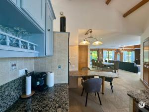 a kitchen with a table and a dining room at Gîte des Pruniers in Saint-Germain-le-Rocheux