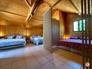 two beds in a room with wooden ceilings at Gîte des Pruniers in Saint-Germain-le-Rocheux +34 photos