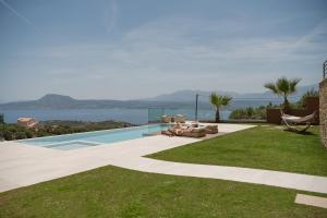 a swimming pool with a view of the water at Villa Niolos II in Stérnai
