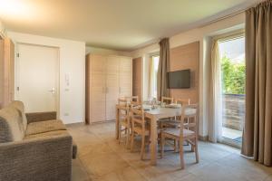 a kitchen and dining room with a table and chairs at Molveno Garden Suite in Molveno