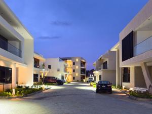 a car parked in a parking lot between two buildings at Horizon Apartment at THE HIDDEN DOMUS I Pool View in Accra