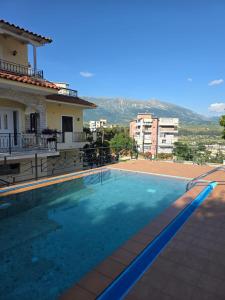 a swimming pool in front of a house at Family Vacation Home in Gjirokastër