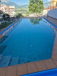 a large swimming pool with blue water at Family Vacation Home in Gjirokastër +18 photos