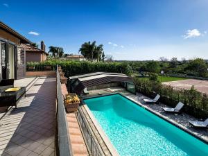 a swimming pool in a yard with two chairs and a patio at Villa Di Marmo in Trappitello