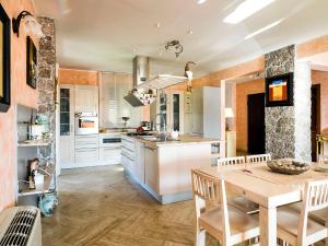 a kitchen with white cabinets and a wooden table at Villa Di Marmo in Trappitello