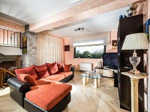 a living room with a couch and a tv at Villa Di Marmo in Trappitello