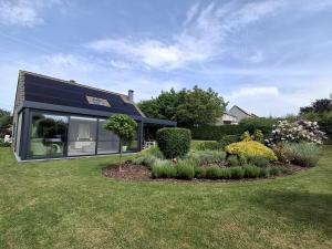 a house with solar panels on top of a yard at LE CLOS DU MONTYS in Louveigné