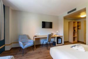 a hotel room with a desk and two chairs at Travelodge Madrid Arturo Soria in Madrid