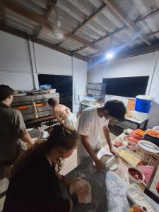 a group of people in a kitchen preparing food at Fat Monkey in Koh Rong Island