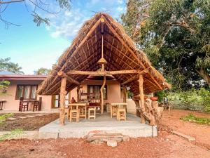a hut with a table and chairs in front of a house at Mahagedara Villa Wilpattu in Nochchiyagama