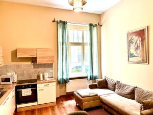 a living room with a couch and a kitchen at Oasis Valley Karlovy Vary Center in Karlovy Vary