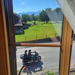 two motorcycles parked on a road through a window at 1 Zimmer Unterkunft in Spiez +1 photo